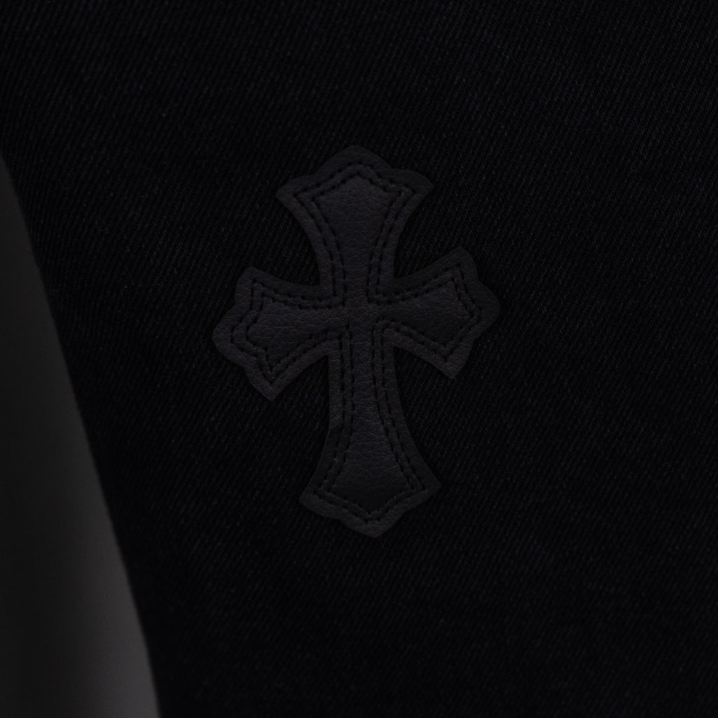 Black denim pants with embroidered cross emblem patch