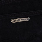 Black denim pants with stitched logo tab near the pocket