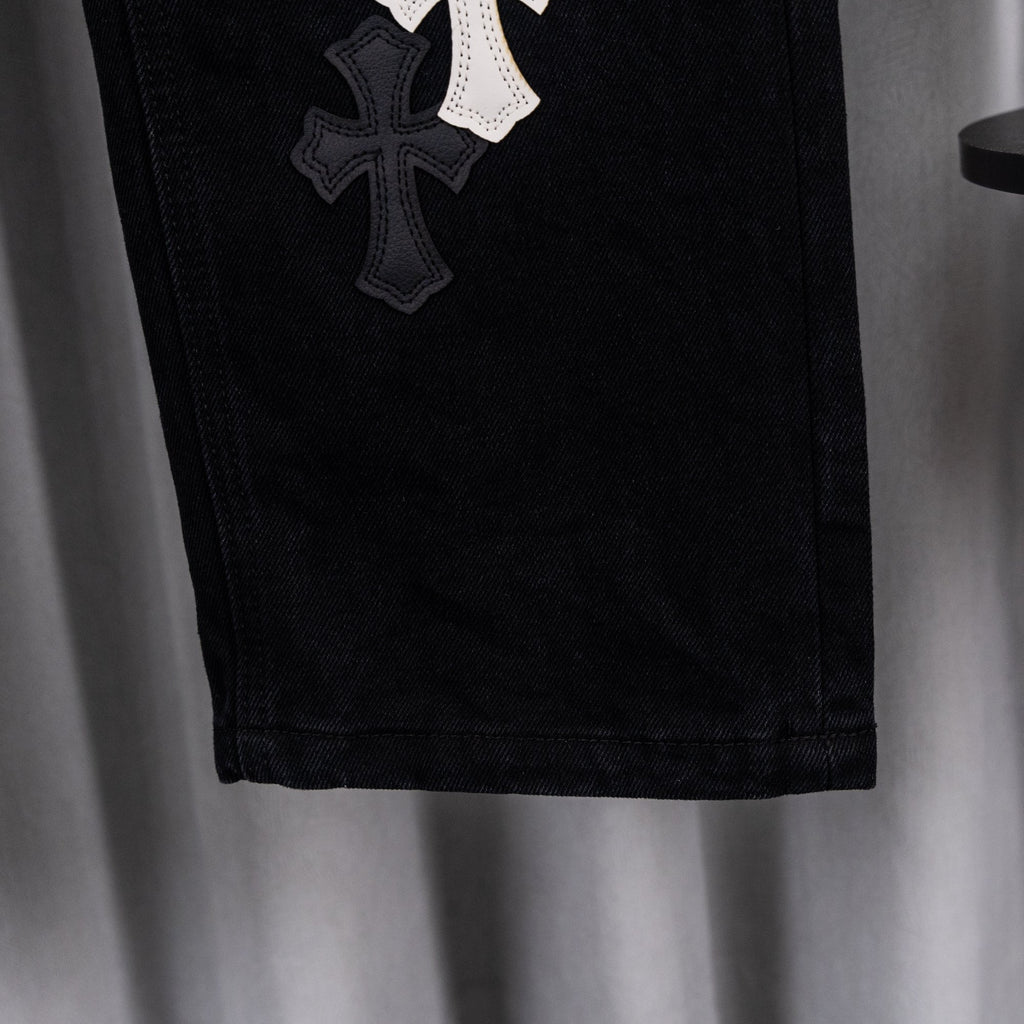 Black denim pants with stitched cross patch on the side