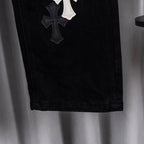 Black denim pants with stitched cross patch on the side