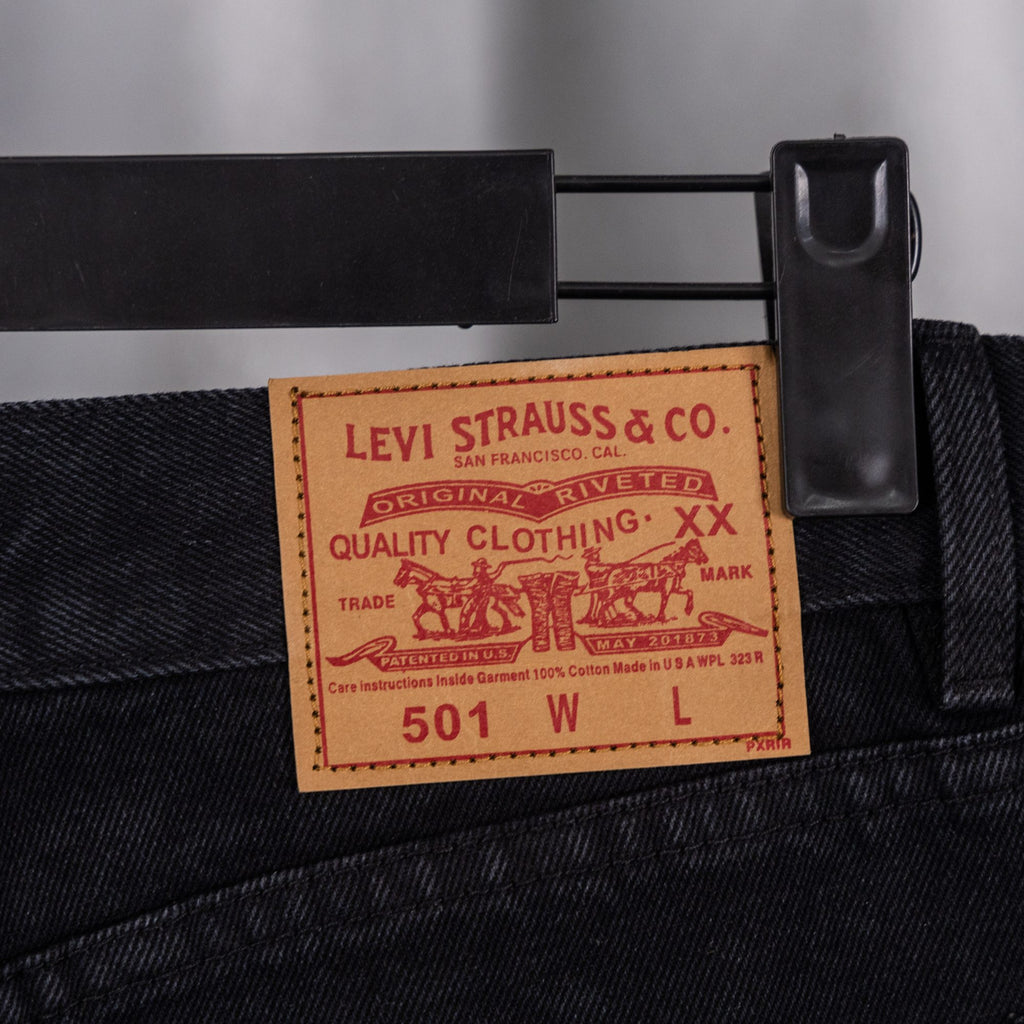 Black denim pants with Levi Strauss 501 care label at waistband
