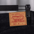 Black denim pants with Levi Strauss 501 care label at waistband