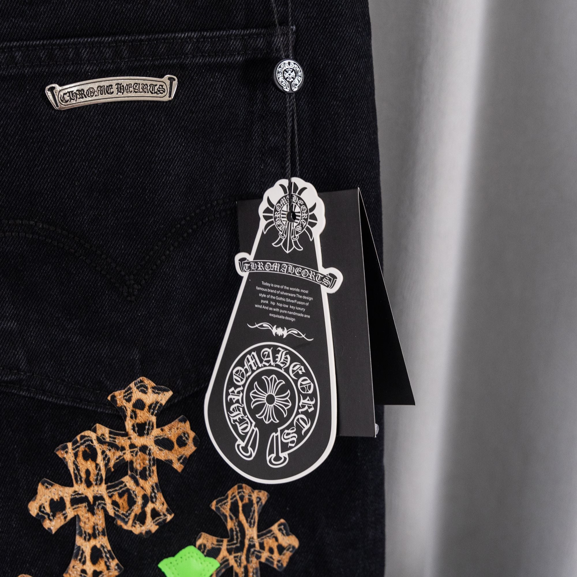 Black denim Chrome pants with leopard-style graphic and hanging tag
