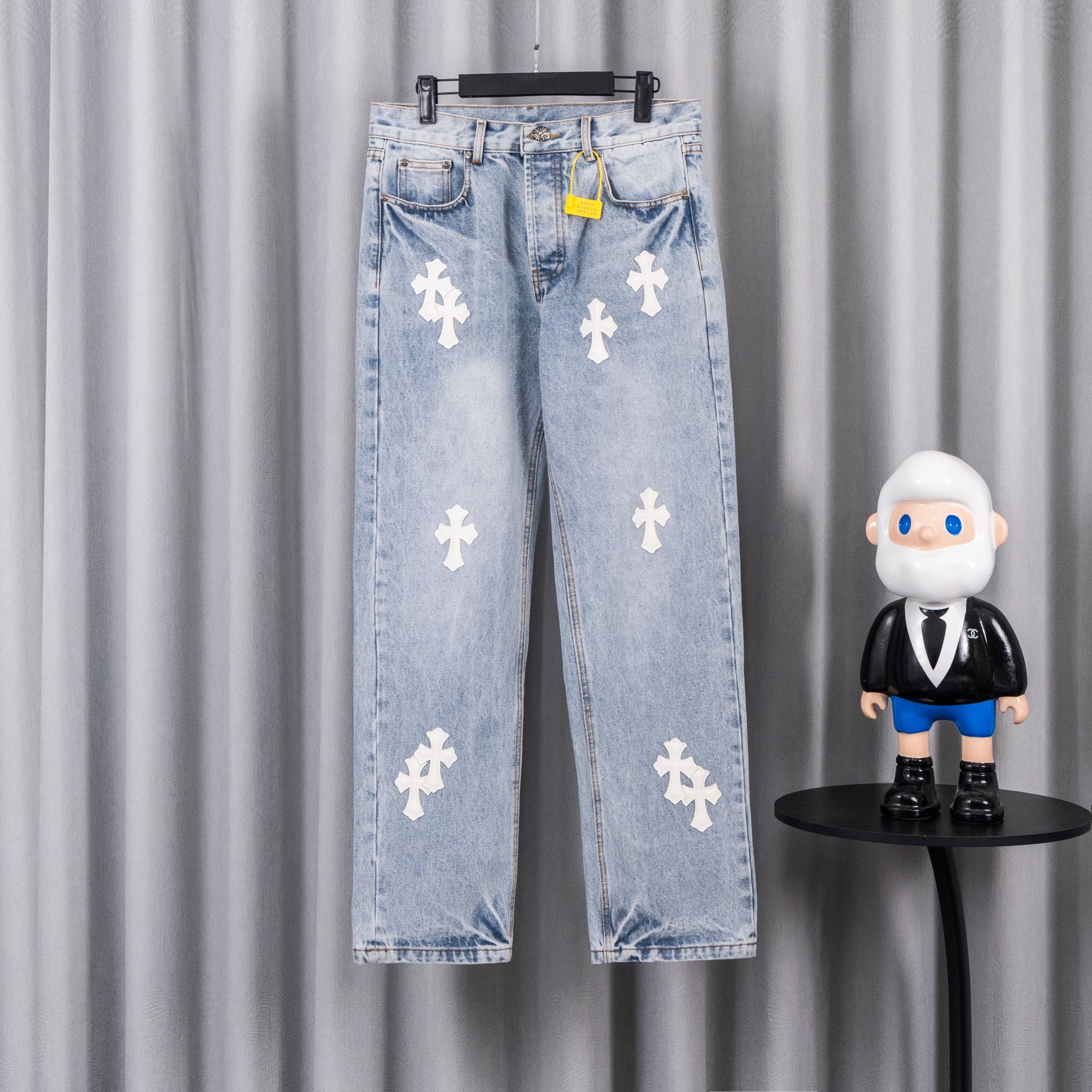 Light blue denim jeans with white cross patches, button fly and belt loops.