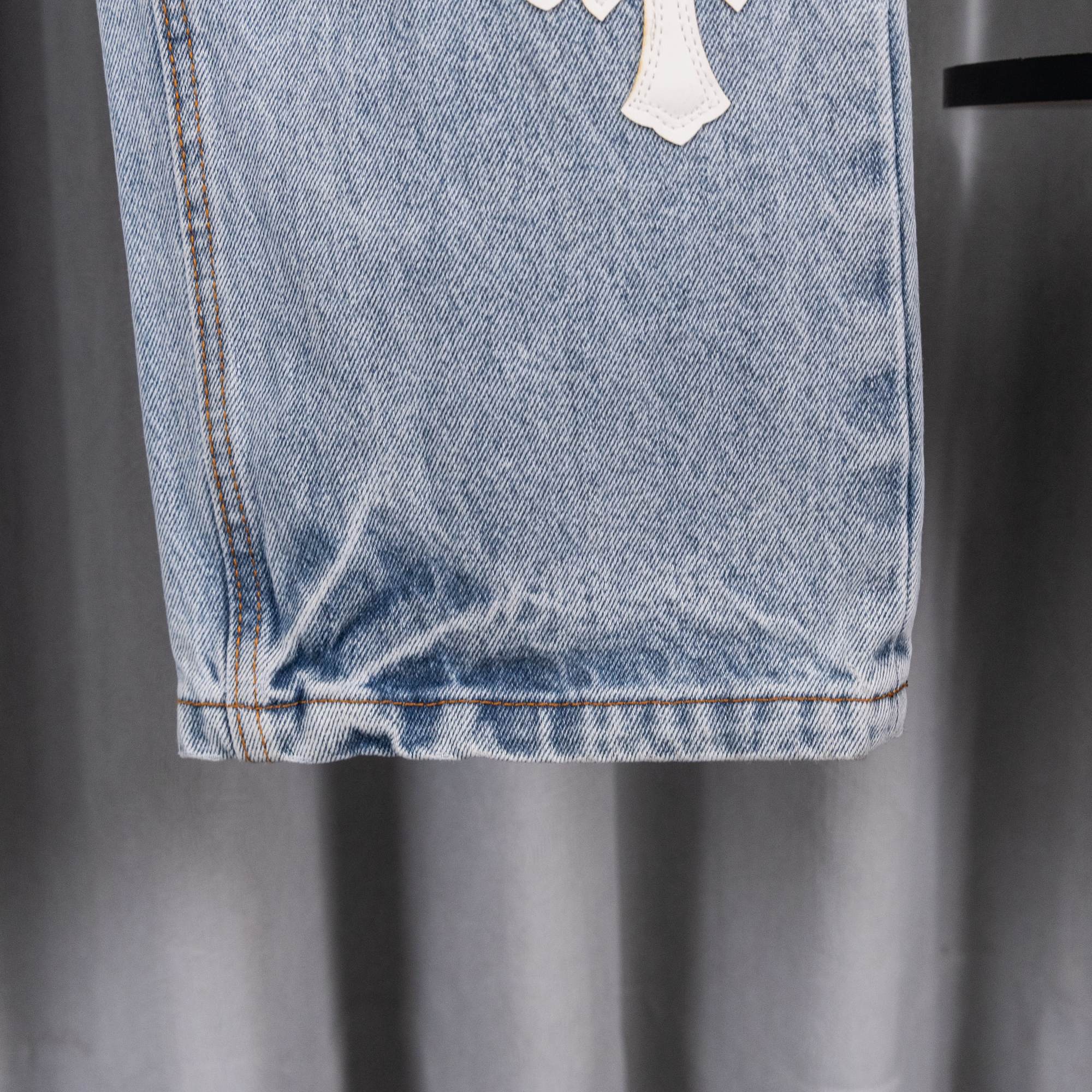 Chrome pants hem and cuffs detail on light blue denim with visible stitching