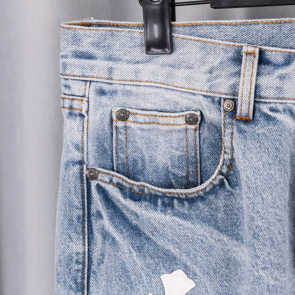 Chrome pants waistband close-up: belt loops, button, coin pocket, white cross patch