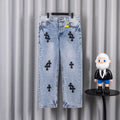 Light blue denim jeans with black cross patches and straight legs