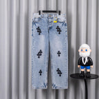 Light blue denim jeans with black cross patches and straight legs