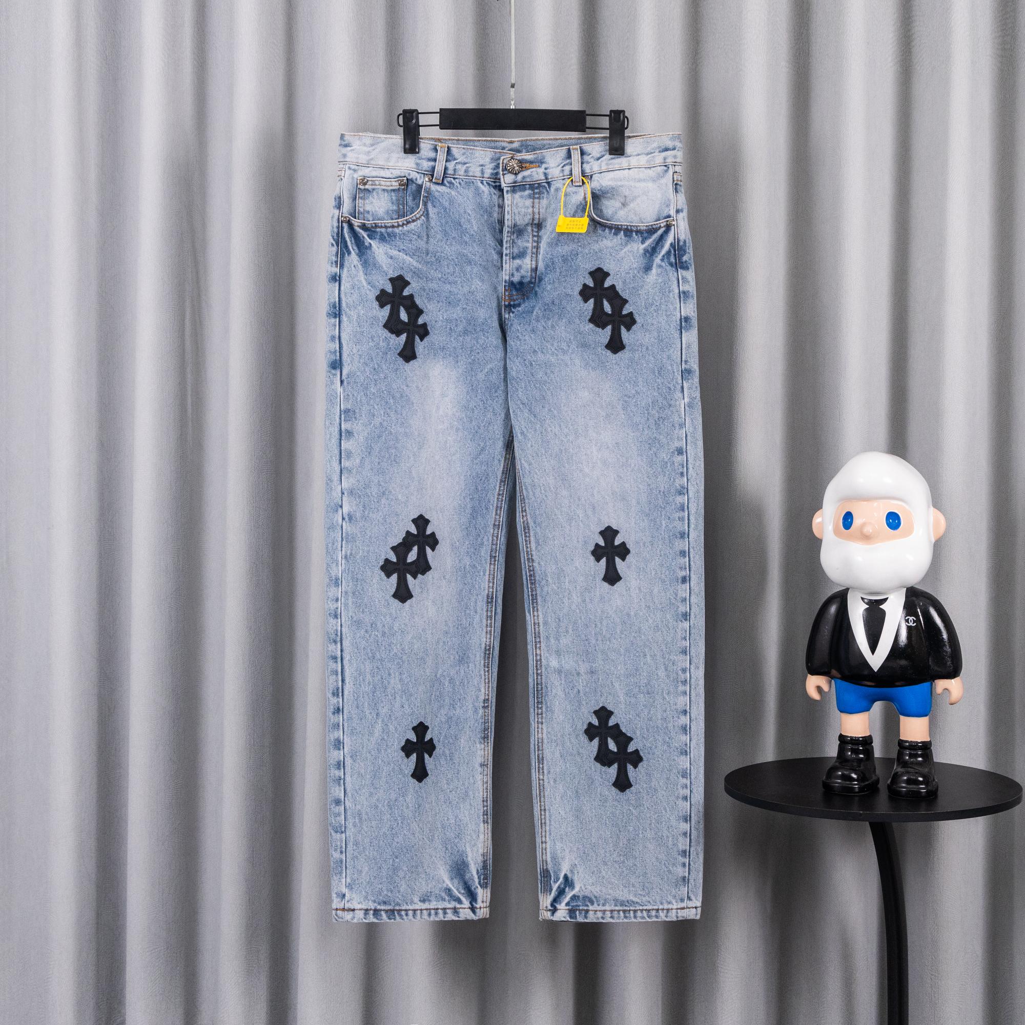 Light blue denim jeans with black cross patches and straight legs
