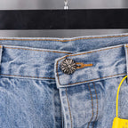 Light blue denim pocket with small embroidered detail and stitched waistband seam
