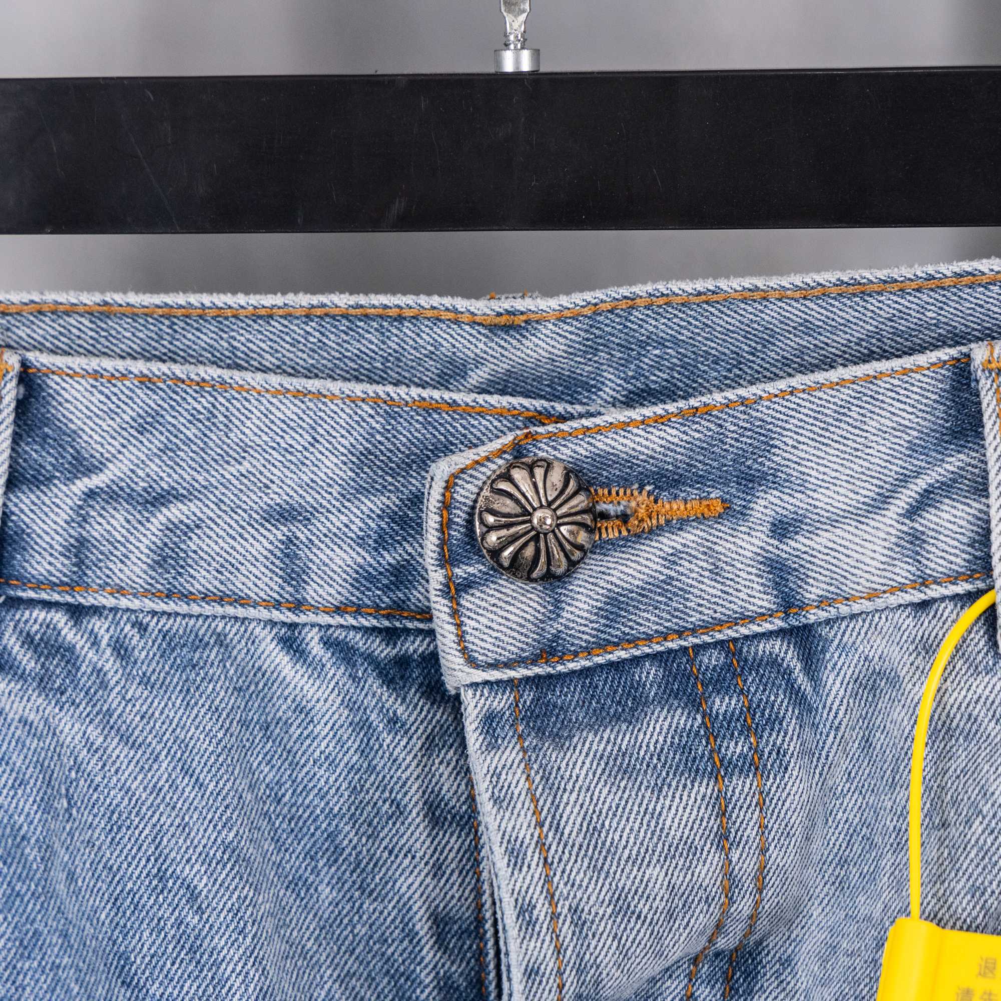 Light blue denim pocket with small embroidered detail and stitched waistband seam