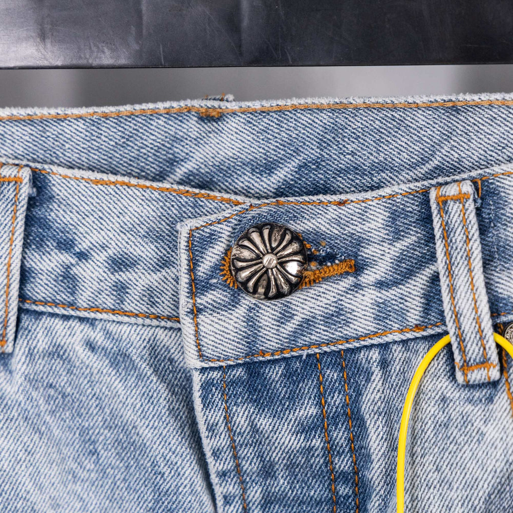 Light blue denim jeans back pocket with decorative snap and stitching
