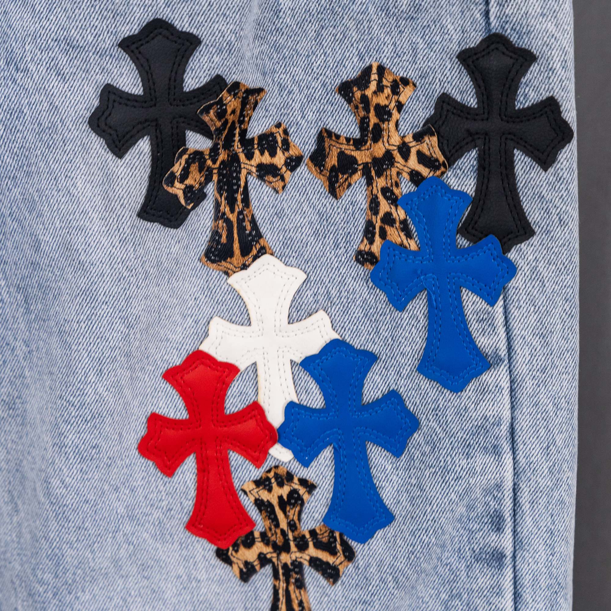 Light blue denim jeans with multicolor cross applique design