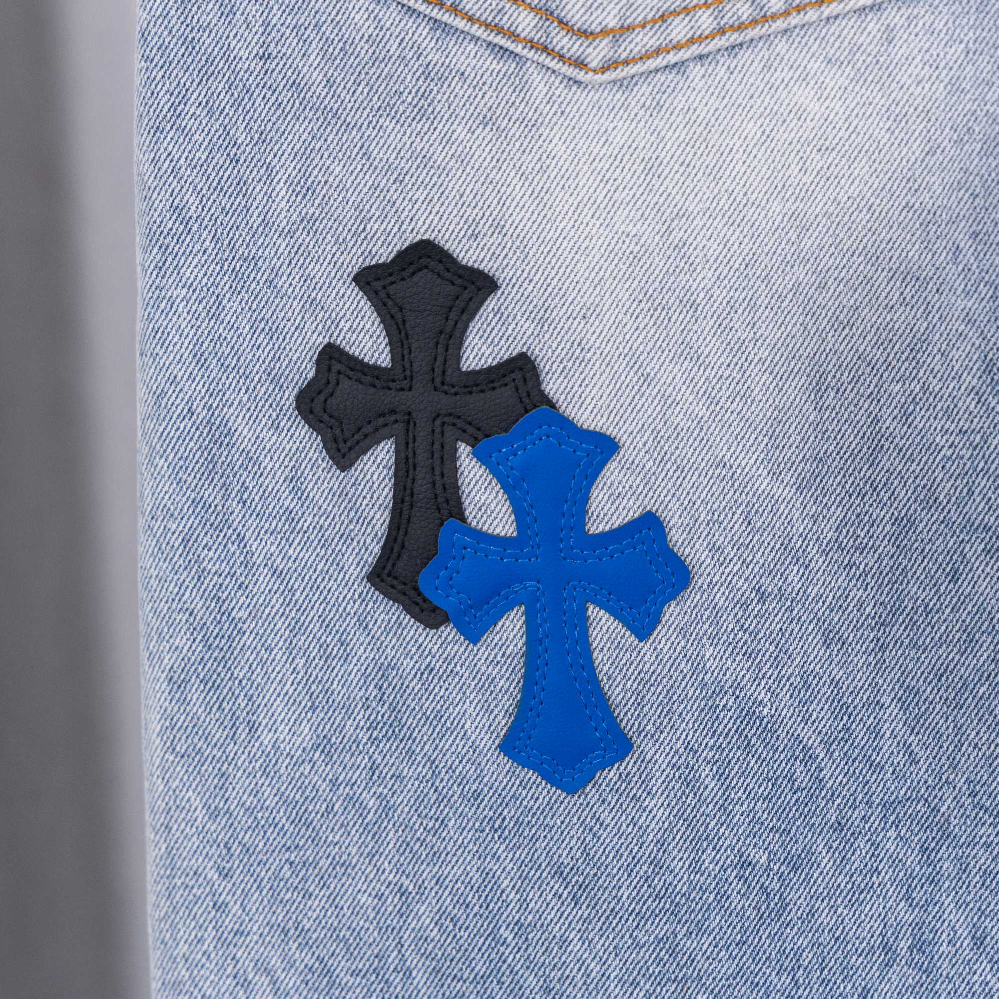 Light blue denim jeans with black and blue cross appliques