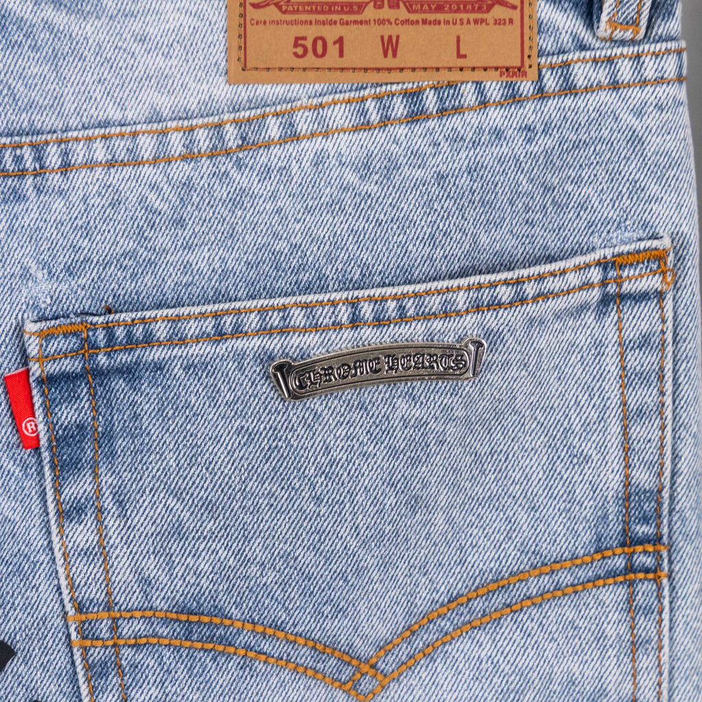 Light blue denim jeans back pocket with metal brand tag and tan topstitching