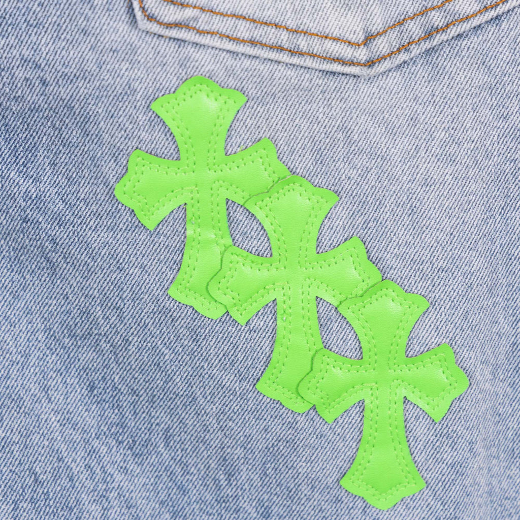 Neon green cross patch appliques on light blue denim fabric