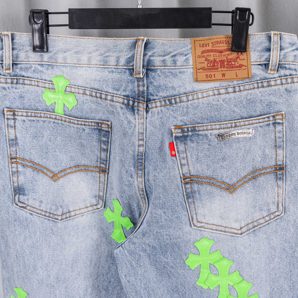 Light blue denim pants with Levi Strauss tag, back yoke stitching, neon green cross patches