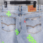 Light blue denim pants with Levi Strauss tag, back yoke stitching, neon green cross patches