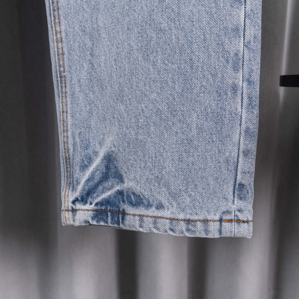 Light blue denim pants hem and side seam close-up