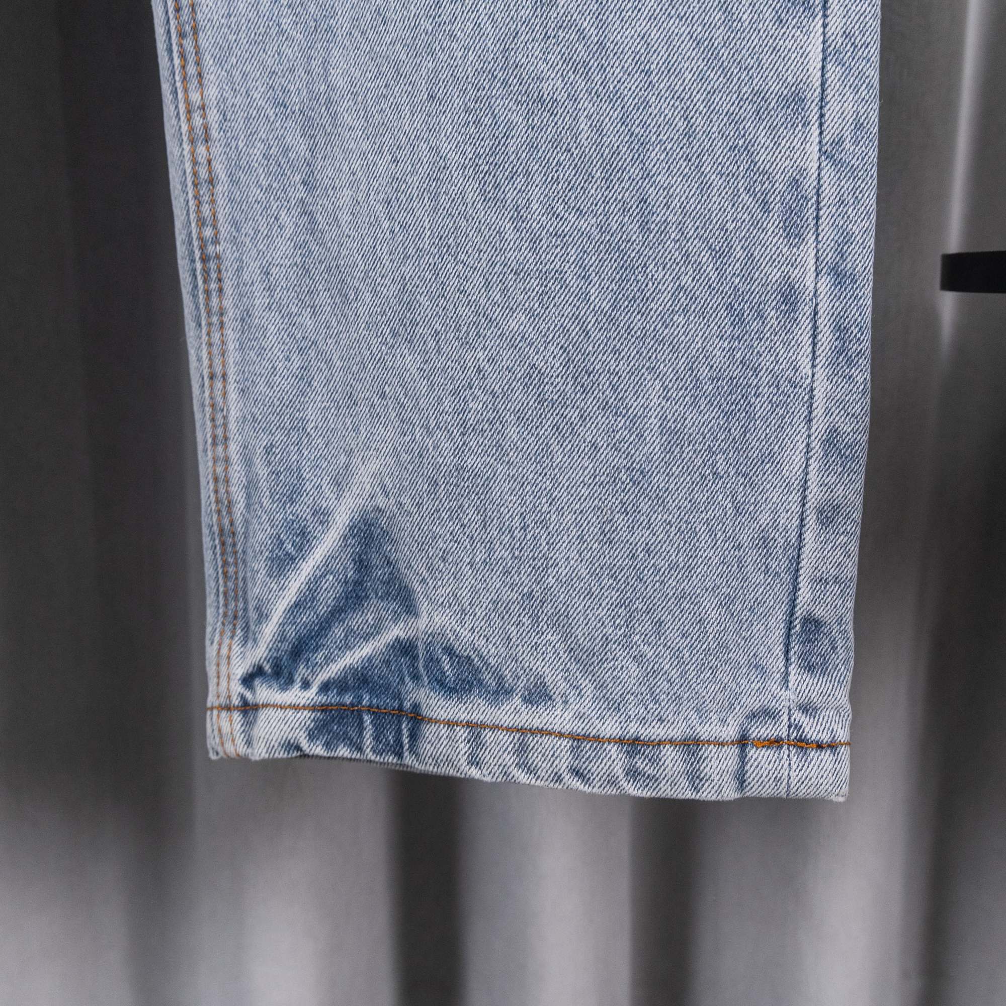 Light blue denim pants hem and side seam close-up