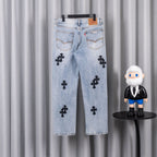 Light wash denim pants with black cross patches and belt loops