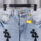 Denim pants waistband with black cross patches and yellow hanging tag
