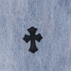 Light wash denim pants with black cross patch applique on fabric