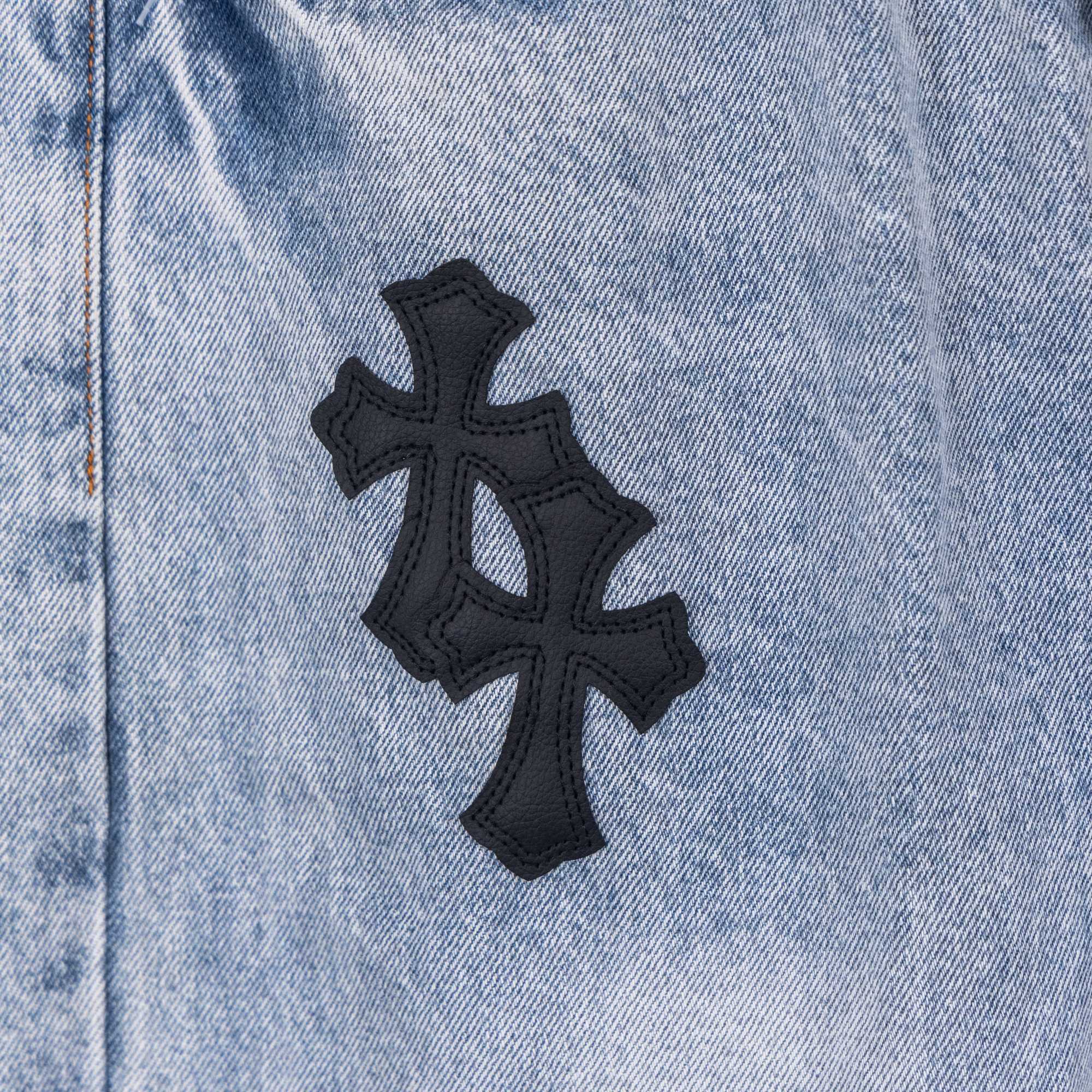 Light blue denim pants with black cross patch applique