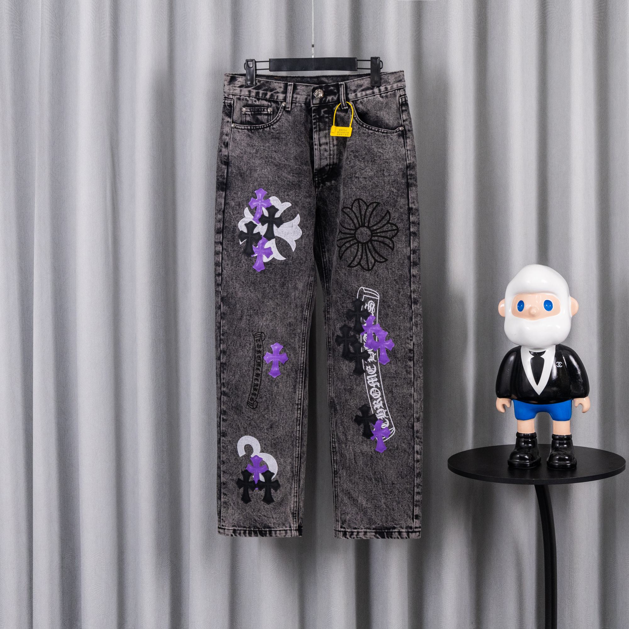 Chrome pants with gray wash, purple and black patches, and a yellow tag at the waist