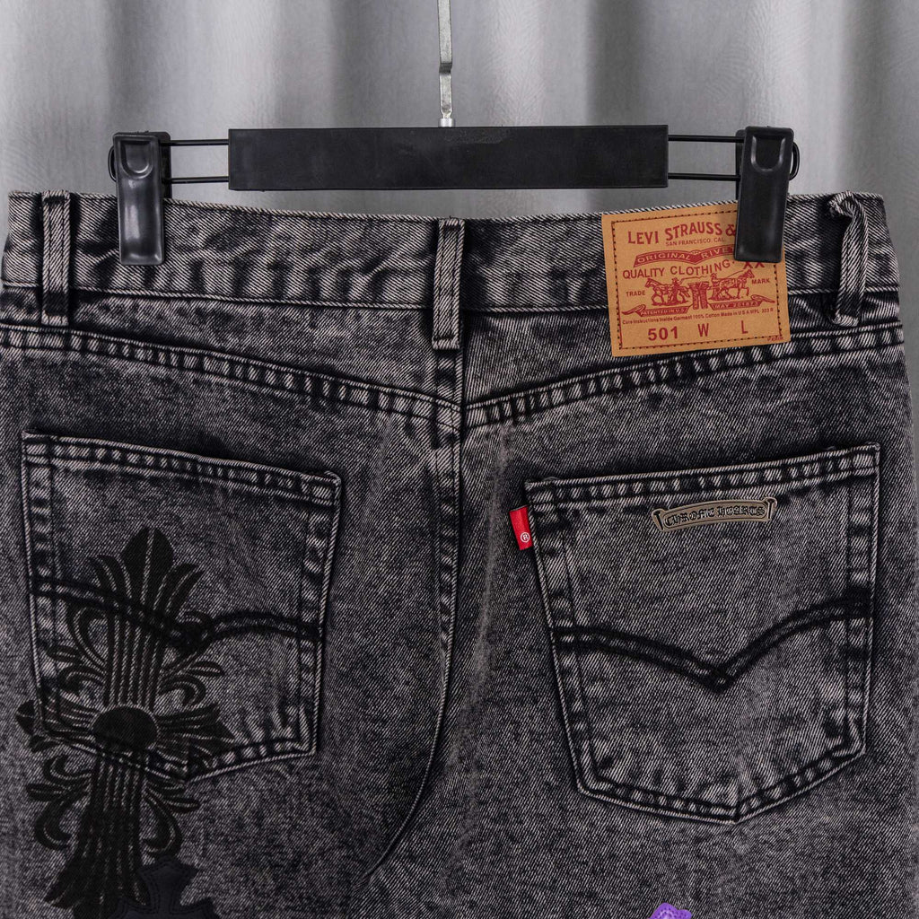 Chrome pants front close-up: gray denim pockets with printed fabric patches