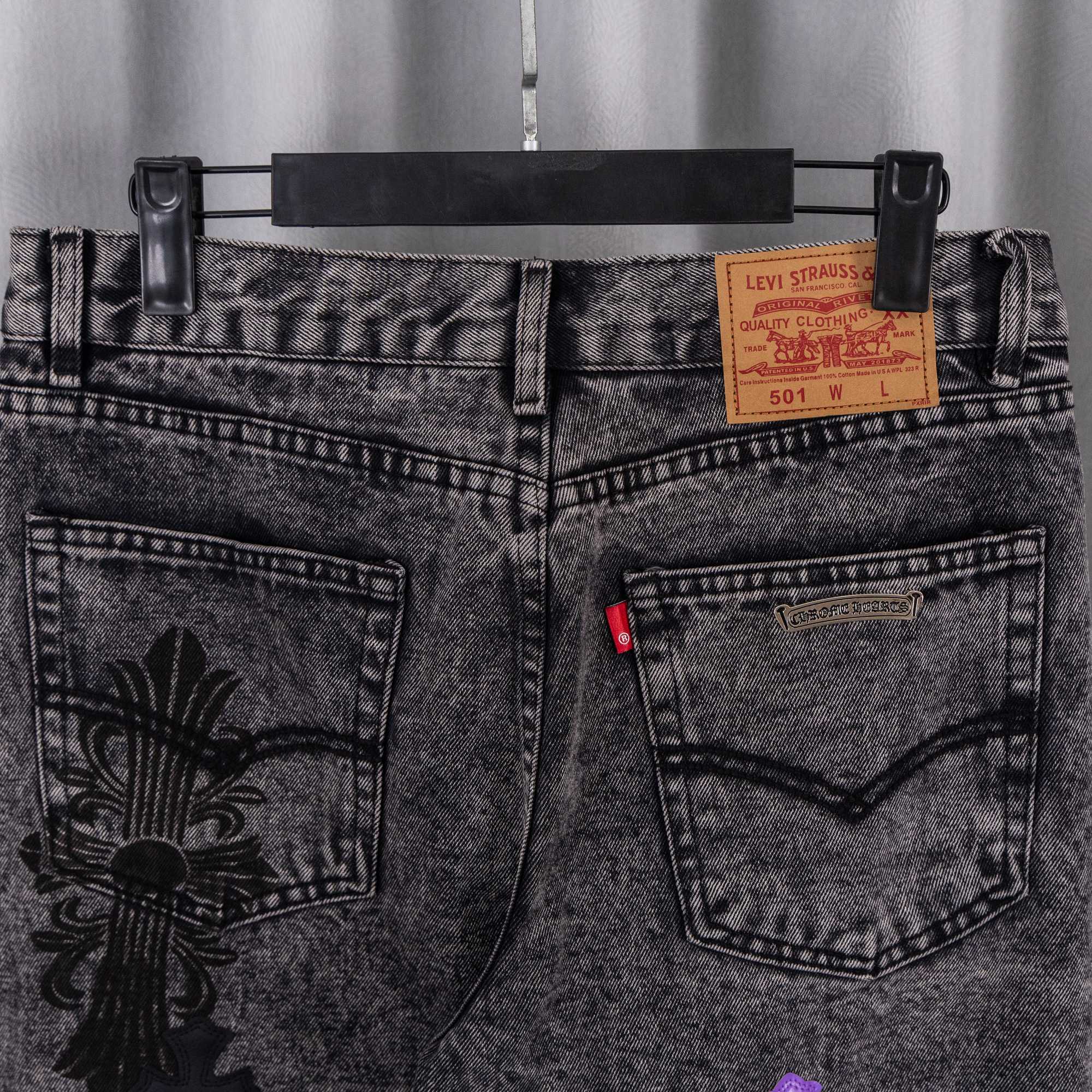 Chrome pants front close-up: gray denim pockets with printed fabric patches