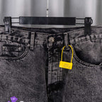 Chrome pants front close-up: gray denim with belt loops and a yellow hanging tag