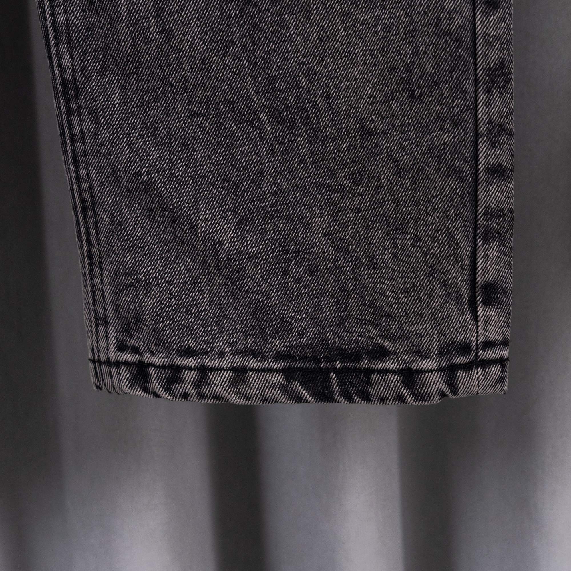 Chrome pants hem close-up on gray denim with visible stitching and folded cuff