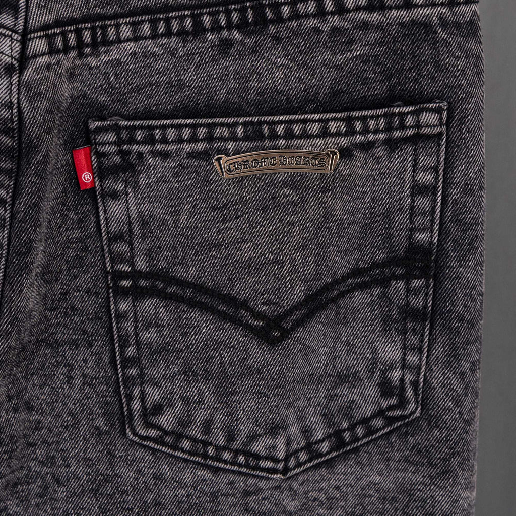 Chrome pants back pocket close-up with leather-like patch and stitched V seam