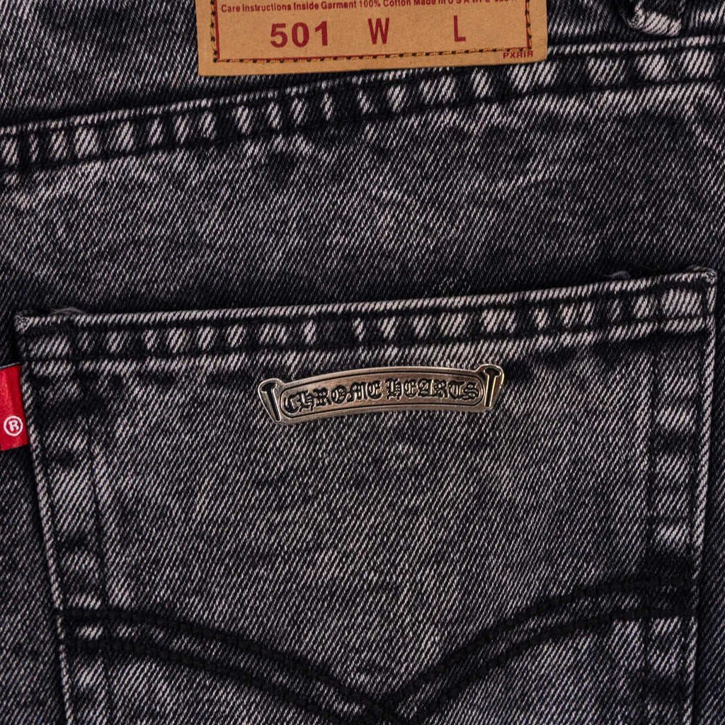 Chrome pants back pocket close-up with metal logo patch and size label above