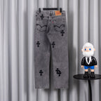 Gray denim pants with black cross applique print, front view on hanger
