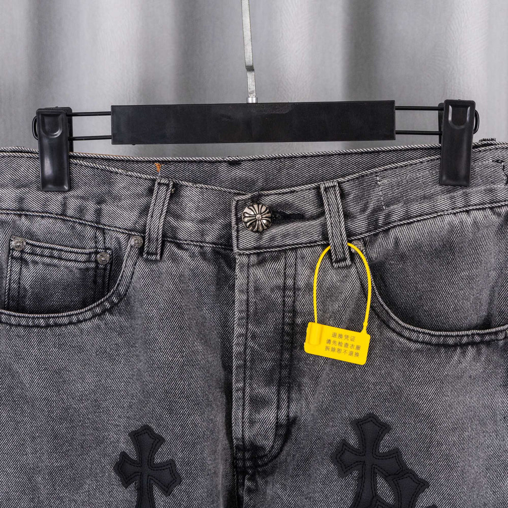 Gray denim pants waistband close-up with metal button, belt loops, and yellow tag