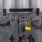 Gray denim pants waistband close-up with metal button, belt loops, and yellow tag