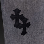 Gray denim pants close-up of large black cross applique