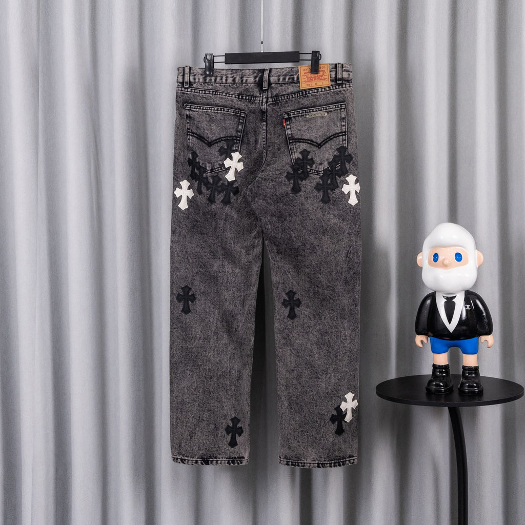 Gray denim pants with dark and white cross patches, belt loops at waistband.