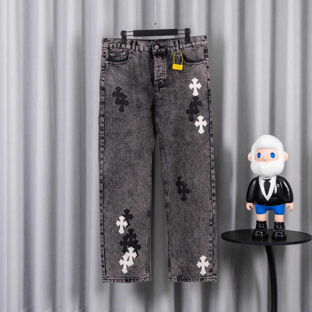 Gray denim pants with cross appliques and front button-and-zip closure.