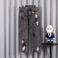 Gray denim pants with cross appliques and front button-and-zip closure.