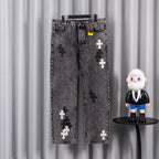 Gray denim pants with cross appliques and front button-and-zip closure.