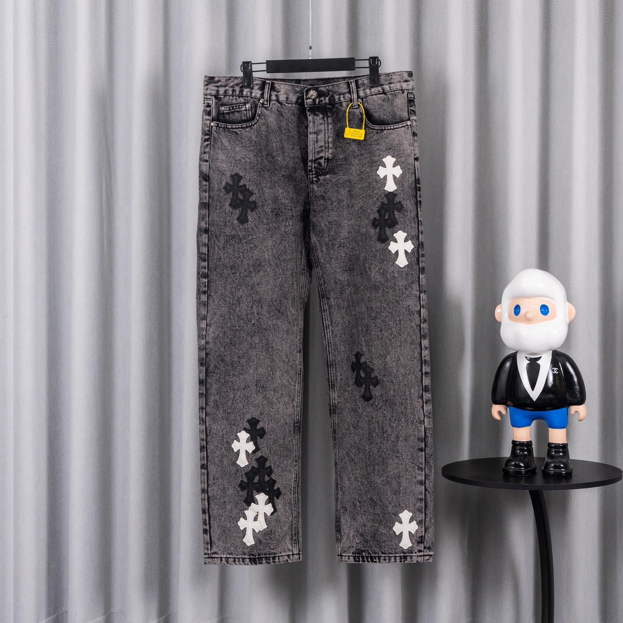 Gray denim pants with cross appliques and front button-and-zip closure.