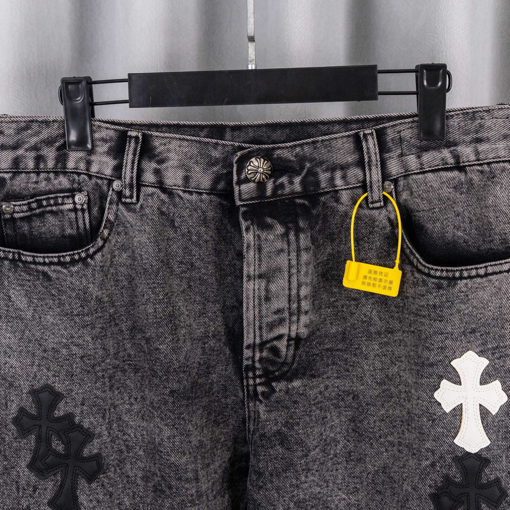 Denim pants waist with button, belt loops, and yellow hang tag near coin pocket.