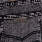Denim pants back pocket with small metal brand patch.