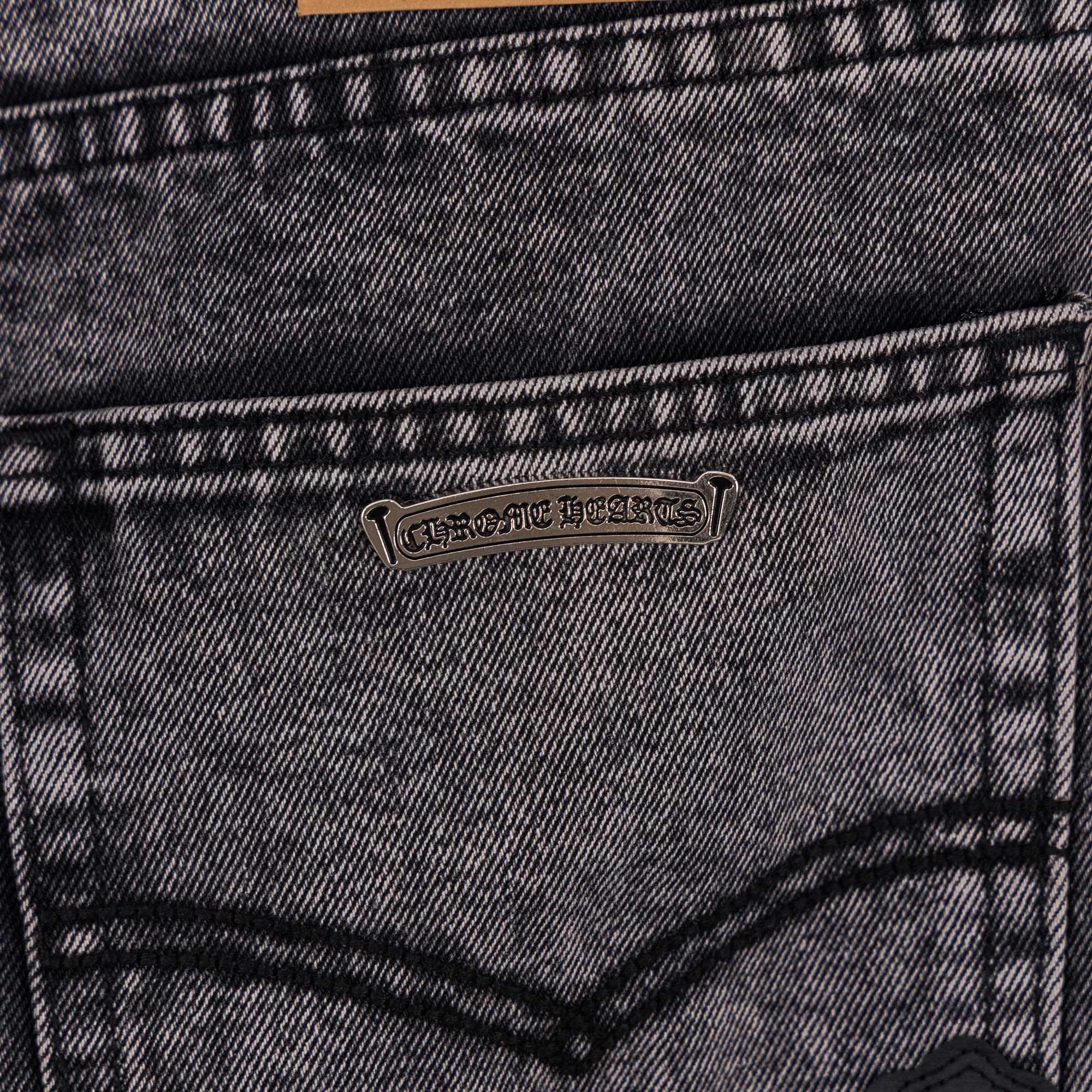 Denim pants back pocket with small metal brand patch.
