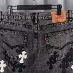 Denim pants front with Levi's label, belt loops, and black/white cross patches.