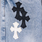 Black and white cross appliques on light blue denim jeans.