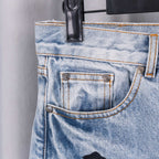 Light blue denim jeans close-up: front pocket and stitching details.